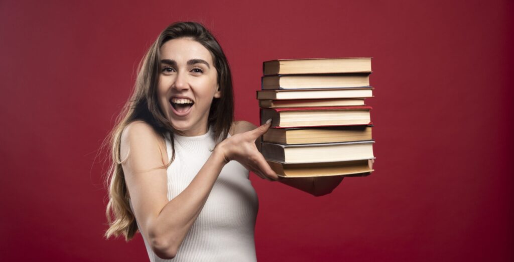 Student carrying a tall stack of books