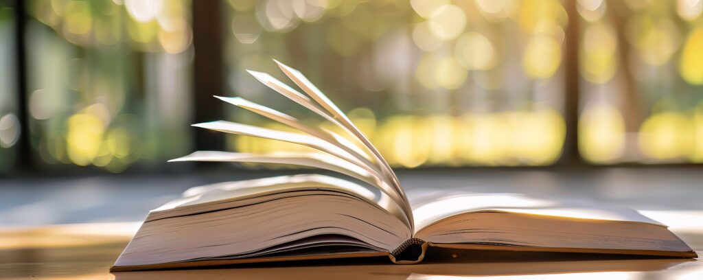 Open book with turning pages in a sunlit room
