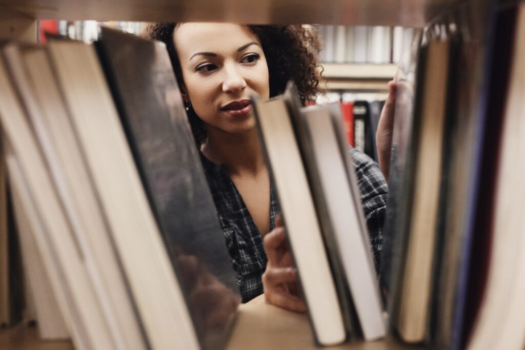 Student studying among books in a library